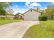 Spacious driveway leading to a two-car garage of a single-Gathering home with a manicured lawn at 2141 Coachman Rd, Spring Hill, FL 34608