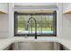 Kitchen sink with a view of the pool in the backyard through a large window at 2141 Coachman Rd, Spring Hill, FL 34608