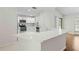Bright kitchen features white cabinets, stainless steel appliances, and a quartz countertop breakfast bar at 2141 Coachman Rd, Spring Hill, FL 34608