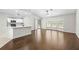 Open concept living area features wood floors, a ceiling fan, and access to the kitchen at 2141 Coachman Rd, Spring Hill, FL 34608