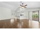 Large living area with wood floors and access to the kitchen and outdoor space at 2141 Coachman Rd, Spring Hill, FL 34608