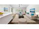 Living room staged with area rug, sofa and side chairs, and a view into the kitchen at 2141 Coachman Rd, Spring Hill, FL 34608