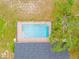 Aerial view of a screened-in pool, surrounded by lush greenery and mature trees at 2141 Coachman Rd, Spring Hill, FL 34608