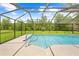 Sparkling pool with screened enclosure, surrounded by lush greenery at 2141 Coachman Rd, Spring Hill, FL 34608