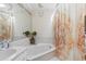 This is a well-lit bathroom with a tub, unique curtain, and a nice mirror for an appealing space at 2199 Blue Tern Dr, Palm Harbor, FL 34683