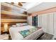 Comfortable bedroom featuring a wood accent wall, a ceiling fan, and generous natural light at 2199 Blue Tern Dr, Palm Harbor, FL 34683