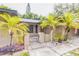Inviting home entrance featuring a cozy walkway, lush landscaping, and charming accent lighting at 2199 Blue Tern Dr, Palm Harbor, FL 34683