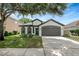 Charming single-Gathering home featuring a well-manicured lawn, a two-car garage and three arched windows at 22824 Marsh Wren Dr, Land O Lakes, FL 34639