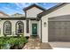 Beautiful home exterior showcasing a tile pathway, a two-car garage and three arched windows at 22824 Marsh Wren Dr, Land O Lakes, FL 34639