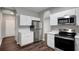 Bright kitchen with stainless steel refrigerator, white cabinets and wood-look flooring at 22824 Marsh Wren Dr, Land O Lakes, FL 34639