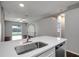 Open kitchen with quartz countertop island with a stainless steel dishwasher and sink at 22824 Marsh Wren Dr, Land O Lakes, FL 34639
