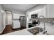 Well-lit kitchen with white cabinets, stainless appliances, wood-look flooring, and quartz countertop at 22824 Marsh Wren Dr, Land O Lakes, FL 34639