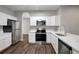 Well-lit kitchen featuring stainless steel appliances and white cabinets and quartz countertop at 22824 Marsh Wren Dr, Land O Lakes, FL 34639