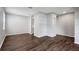 Living room featuring open archways, gray walls, and wood-look flooring at 22824 Marsh Wren Dr, Land O Lakes, FL 34639