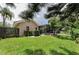 Spacious backyard with healthy green lawn, mature trees, and a screened-in pool area at 2455 Anthony Ave, Clearwater, FL 33759