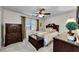 Bedroom showcasing a dark wooden dresser set, a ceiling fan, and a window with classic plantation shutters at 2455 Anthony Ave, Clearwater, FL 33759