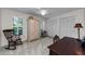 Bright bedroom featuring soft carpeting, a large wardrobe, and a cozy rocking chair near a window at 2455 Anthony Ave, Clearwater, FL 33759