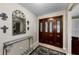 Elegant entryway featuring a decorative mirror, tiled floor, and an ornate glass-paneled front door at 2455 Anthony Ave, Clearwater, FL 33759