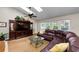 Bright living room featuring a vaulted ceiling with skylights, a fireplace, and a large leather couch at 2455 Anthony Ave, Clearwater, FL 33759