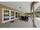 Covered patio features an outdoor dining set near glass doors with a view of the refreshing pool at 2455 Anthony Ave, Clearwater, FL 33759