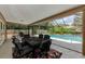 Screened patio with outdoor dining set overlooking a sparkling pool and lush, landscaped backyard at 2455 Anthony Ave, Clearwater, FL 33759