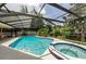 Inviting screened-in pool and spa, with blue tile trim and a spacious deck for lounging at 2455 Anthony Ave, Clearwater, FL 33759