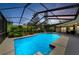 Sparkling blue swimming pool with screened-in enclosure and lush landscaping, perfect for relaxation and recreation at 2455 Anthony Ave, Clearwater, FL 33759