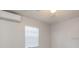 Bright bedroom featuring a ceiling fan, a window with blinds, and efficient mini-split AC unit at 2926 Fairfield S Ave, St Petersburg, FL 33712