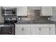 Updated kitchen with stainless steel appliances, granite countertops, modern backsplash, and white cabinets at 2926 Fairfield S Ave, St Petersburg, FL 33712