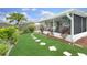 Landscaped backyard featuring a stepping stone path leading to a screened porch and lush greenery at 3026 Cedaridge Dr, Tampa, FL 33618