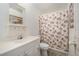 Clean bathroom features a white vanity, toilet, and a shower with floral curtain at 3026 Cedaridge Dr, Tampa, FL 33618