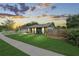 Charming single-story home with a lush green lawn, a welcoming walkway, and a delightful sunset backdrop at 3026 Cedaridge Dr, Tampa, FL 33618