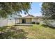 Back view of home featuring screened-in porch, privacy fence and well maintained lawn at 3443 Fyfield Court, Land O Lakes, FL 34638