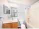 Well-lit bathroom with tiled shower, wood vanity, modern mirror, and blue accent wall at 3443 Fyfield Court, Land O Lakes, FL 34638