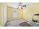 Simple bedroom with yellow walls, carpet, window, ceiling fan, and a closet at 3443 Fyfield Court, Land O Lakes, FL 34638