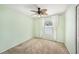 Cozy bedroom with light green walls, a ceiling fan, window, and neutral carpet flooring at 3443 Fyfield Court, Land O Lakes, FL 34638