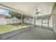 Spacious screened porch with fan and backyard view surrounded by a white fence at 3443 Fyfield Court, Land O Lakes, FL 34638