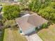 View of the home with pool and screened-in lanai amid lush landscaping from above at 3485 Dothan Ave, Spring Hill, FL 34609