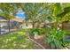 Landscaped backyard featuring lush greenery, a birdbath, and a partially screened-in patio at 3485 Dothan Ave, Spring Hill, FL 34609