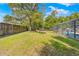 Enjoy a spacious backyard with lush greenery, a secure fence, and an inviting screened-in pool at 3485 Dothan Ave, Spring Hill, FL 34609