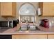 Well-lit kitchen featuring stainless steel sink, archway to living area, and essential appliances at 3485 Dothan Ave, Spring Hill, FL 34609
