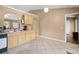An open kitchen features tile flooring, light wood cabinets, and an arched opening to another room at 3485 Dothan Ave, Spring Hill, FL 34609