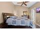 Comfortable bedroom with ceiling fan, dresser, doorway to bathroom and warm, inviting colors at 3485 Dothan Ave, Spring Hill, FL 34609