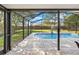 Screened-in lanai features a refreshing swimming pool, basketball hoop, and surrounding greenery at 3485 Dothan Ave, Spring Hill, FL 34609