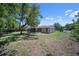 Large backyard featuring a screened-in patio and mature trees, perfect for relaxation and entertainment at 3529 Orion Rd, Spring Hill, FL 34606
