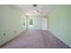 Bright bedroom showcasing neutral carpeting, light green walls, and a ceiling fan for comfortable living at 3529 Orion Rd, Spring Hill, FL 34606