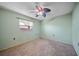 Cozy bedroom featuring a neutral carpet, ceiling fan, and a bright window at 3529 Orion Rd, Spring Hill, FL 34606