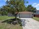 Charming single-story home with a two-car garage and a well-maintained front yard with mature trees at 3529 Orion Rd, Spring Hill, FL 34606