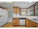 Cozy kitchen features wood cabinets, white countertops, and stainless steel sink under a bright window at 3529 Orion Rd, Spring Hill, FL 34606
