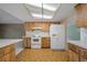 Well-lit kitchen with white appliances and wood cabinets, perfect for Gathering meals at 3529 Orion Rd, Spring Hill, FL 34606